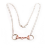 Necklace with a rose gold and silver horse bit pendant on a white background